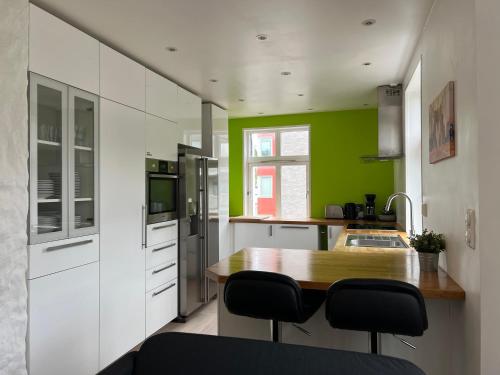 a kitchen with white cabinets and a wooden table at Bendixens vei 57 in Bergen