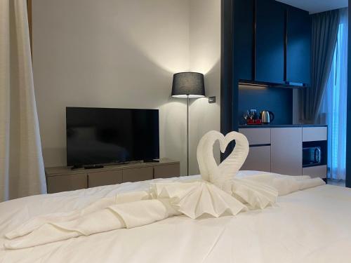 a white bed with two swans forming a heart at Edge Central Pattaya By Su in Pattaya Central