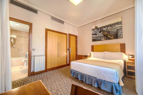 a hotel room with a bed and a bathroom at ITC Mora by Soho Boutique in Madrid