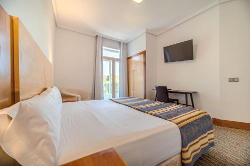 a bedroom with a large bed and a television at ITC Mora by Soho Boutique in Madrid
