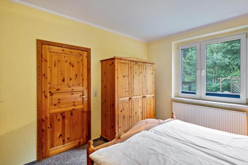 a bedroom with a bed and a wooden cabinet at Krüseliner Mühle - Ferienwohnungen in Krüselin