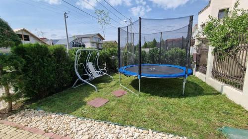a playground with a blue trampoline in a yard at Vila duMio in Eforie Nord