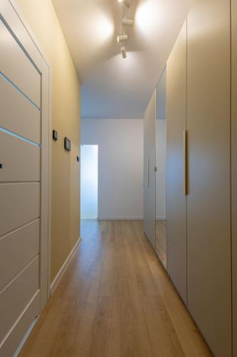 an empty hallway with white cabinets and a door at VIP Apartament Kopisto CENTRUM in Rzeszów