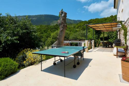 a ping pong table sitting on a patio at Villa Eugenia for 8 people with private pool & large garden only 3 km from the beach in Mošćenička Draga