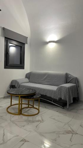 a room with a bed and a table and a tv at Elvis’ Home in Fira