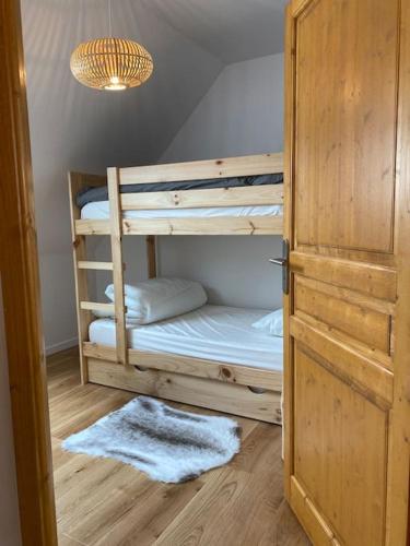 Cette chambre comprend 2 lits superposés et une porte. dans l'établissement Charmant T4 duplex vue montagne, à Loudenvielle
