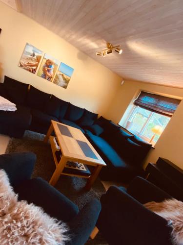 a living room with a blue couch and a table at Villa Hav & Hygge in Borrby