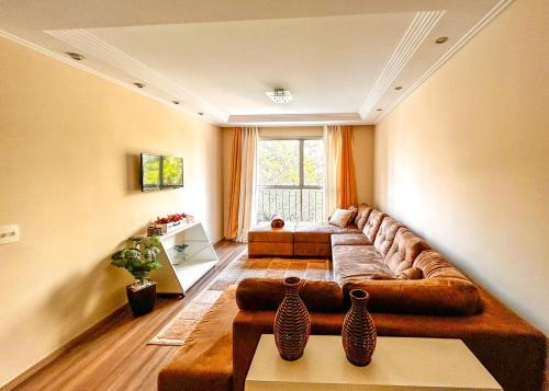 a living room with a couch and two vases on a table at Apto espacoso c WiFi prox a Marginal Pinheiros SP in Sao Paulo