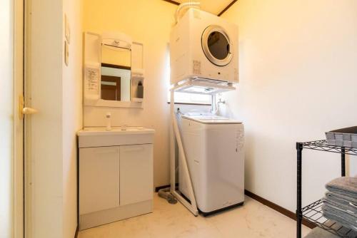 a laundry room with a washing machine and a washer at ジブリパークまで車10分 遊べるキッズハウス1棟貸切り 敷地内無料駐車場あり 最大12名 in Seto