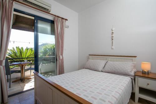 a bedroom with a bed and a balcony with a view at Villa Pebble in Pefki Rhodes
