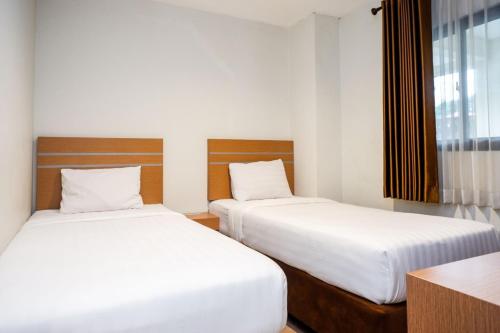 Ένα ή περισσότερα κρεβάτια σε δωμάτιο στο Nostos Guesthouse Wonosobo
