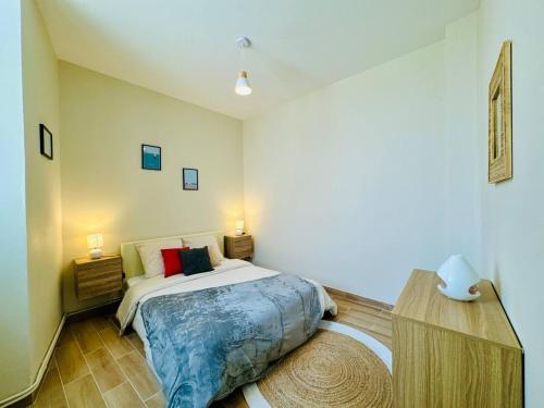 a bedroom with a bed and two lamps and a rug at Le Saint Savinien - By 69ALSACELO - Patio Privé - Idéal Couple & Pros - Canapé convertible - Centre Ville - WiFi Fibre - Check-in Autonome - Parking Facile & Gratuit in Sens