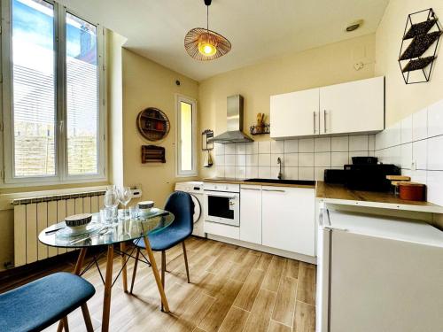 une cuisine avec une table et des chaises bleues dans une cuisine dans l'établissement Le Saint Savinien - By 69ALSACELO - Patio Privé - Idéal Couple & Pros - Canapé convertible - Centre Ville - WiFi Fibre - Check-in Autonome - Parking Facile & Gratuit, à Sens