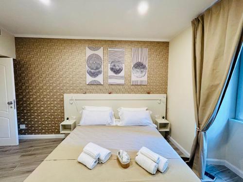 a bedroom with a large bed with towels on it at Domus Altino in Rome