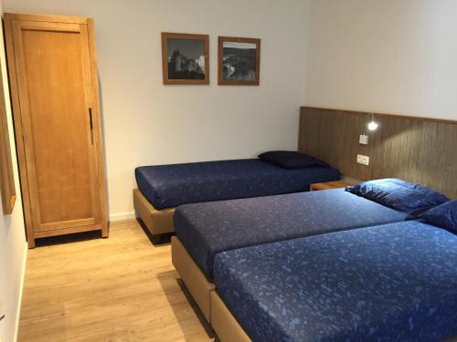 a hotel room with two beds and a door at Holiday Park La Sapinière in Hosingen