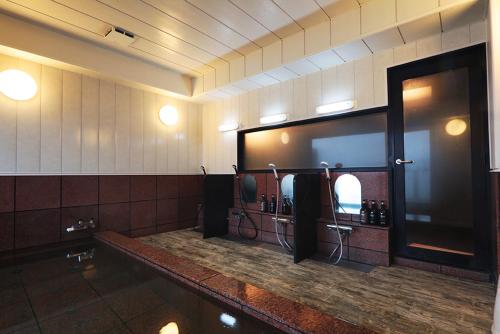a bathroom with a mirror and a hair dryer at 旅館かつみや Katsumiya in Nago