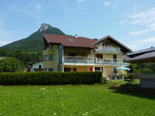 a yellow house with a mountain in the background at Haus Hedwig in Fuschl am See