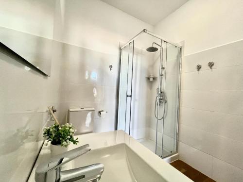 a white bathroom with a shower and a tub at Castillo de Ralph in Guardias Viejas
