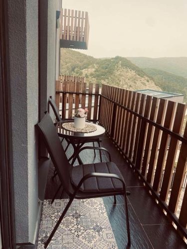 a table and chair on a balcony with a view at Adora's Apartment Mavrovo in Mavrovo