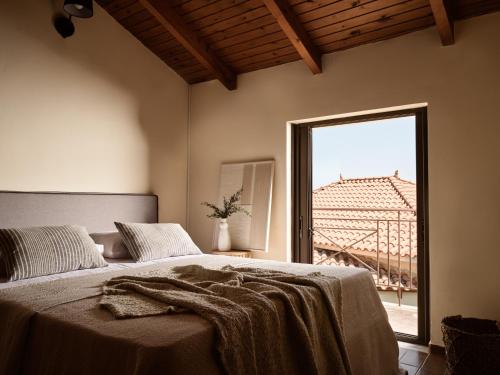 Un dormitorio con una cama y una ventana grande. en Rosa Sea Front Maisonette, en Alikanas