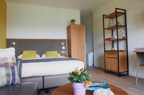 a bedroom with a large bed and a table at Holiday Park La Sapinière in Hosingen