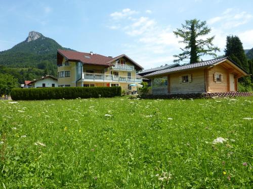 a house and a field of grass with a house at Haus Hedwig in Fuschl am See