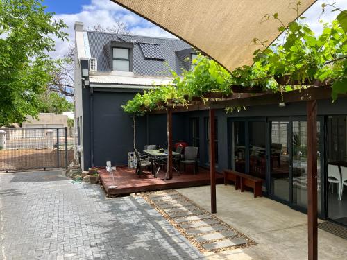 a house with a patio with a table on it at Vlettershof Guest House in Robertson