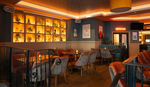 a dining room with tables and chairs in a restaurant at Grand Canal Hotel in Dublin