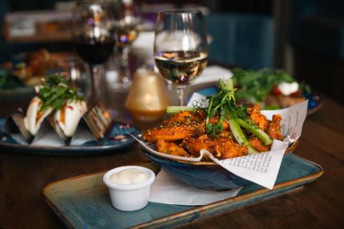 a table with a bowl of food and a glass of wine at Grand Canal Hotel in Dublin