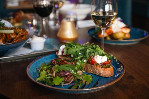 a table with plates of food and a glass of wine at Grand Canal Hotel in Dublin