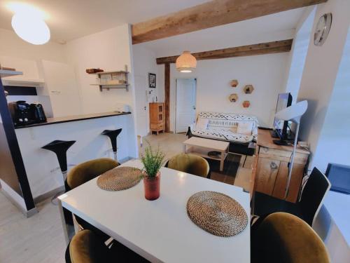 un salon avec une table et des chaises blanches dans l'établissement Appartement lumineux et calme parking gratuit, à Lille