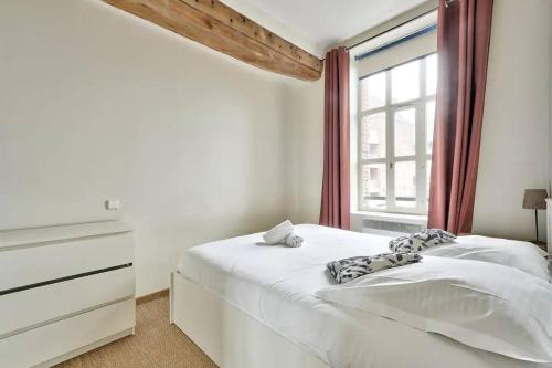 une chambre blanche avec un lit et une fenêtre dans l'établissement Appartement lumineux et calme parking gratuit, à Lille