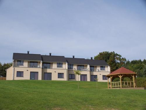 a large building with a gazebo in a field at Holiday Park La Sapinière in Hosingen