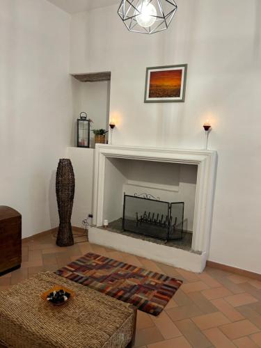 a living room with a fireplace in a white wall at Il Nido in Spello