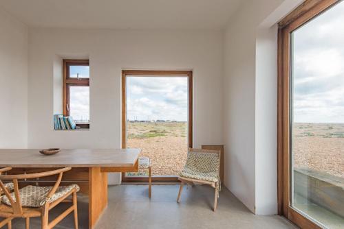 a dining room with a table and chairs and a window at Coastguard Lookout by Bloom Stays in Littlestone-on-Sea