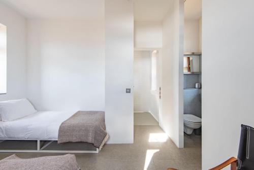 a white bedroom with a bed and a toilet at Coastguard Lookout by Bloom Stays in Littlestone-on-Sea