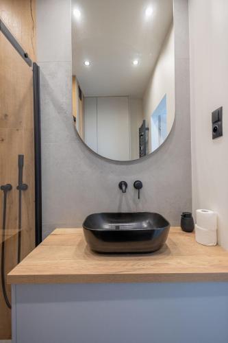a bathroom with a black sink and a mirror at VIP Apartament Kopisto CENTRUM in Rzeszów