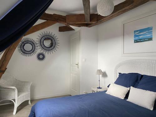 une chambre avec un lit bleu et un miroir dans l'établissement Le Noisetier, à Cerelles