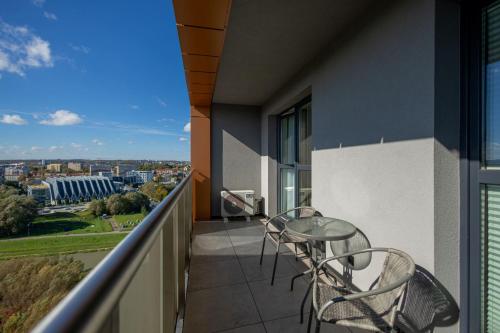 a balcony with a table and chairs on a building at VIP Apartament Kopisto CENTRUM in Rzeszów