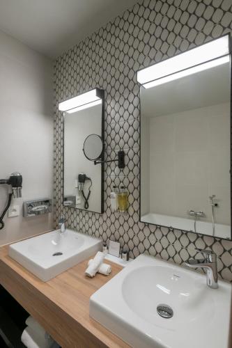 a bathroom with a white sink and a mirror at Martin's Rentmeesterij in Bilzen