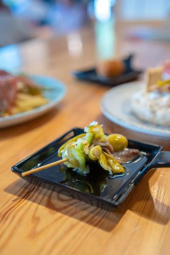 a black plate with food on a wooden table at ITC Mora by Soho Boutique in Madrid
