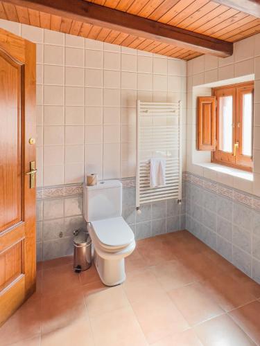 a bathroom with a white toilet and a window at Majordoms - Cal Sabater in Las Escaulas