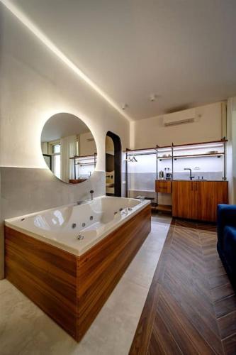 a large bathroom with a large tub and a mirror at Kovac Spa Belgrade Apartment in Belgrade