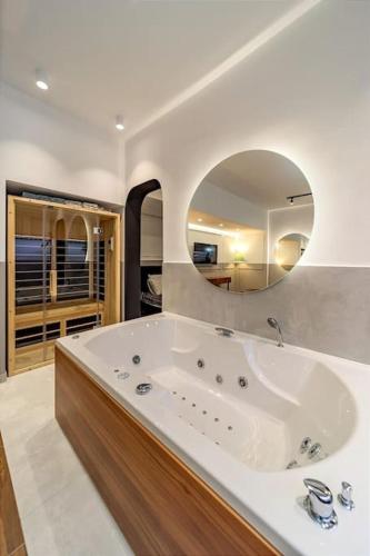 a large bathroom with a tub and a mirror at Kovac Spa Belgrade Apartment in Belgrade