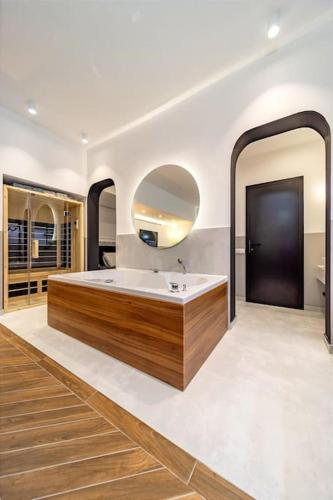 a bathroom with a tub and a large mirror at Kovac Spa Belgrade Apartment in Belgrade
