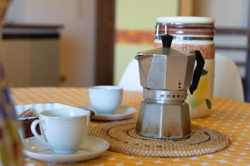 a coffee maker sitting on a table with two cups at Gioiamare in Martinsicuro