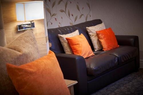 a couch with pillows on it in a living room at Kingston Theatre Hotel in Hull