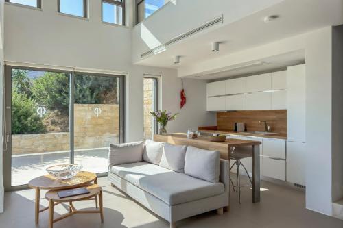 a living room with a couch and a table at Youphoria Sea View Villas in Kissamos