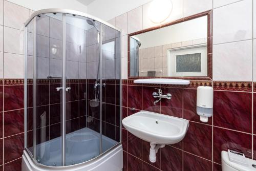 a bathroom with a glass shower and a sink at Sport Hotel in Jelenia Góra