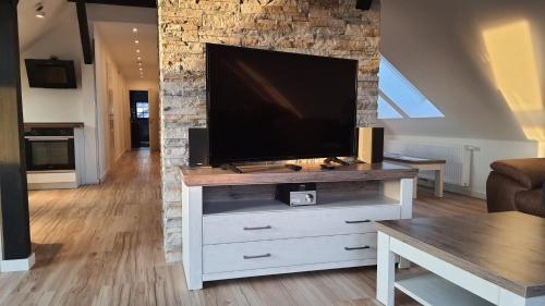 a living room with a television on a white dresser at 5 Sterne Ferienwohnung Dewichow mit Wasserblick & WLAN in Dewichow